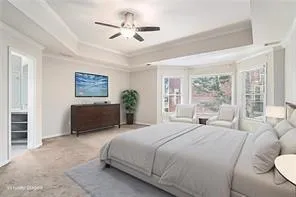 a spacious bedroom with a bed a window and a chandelier