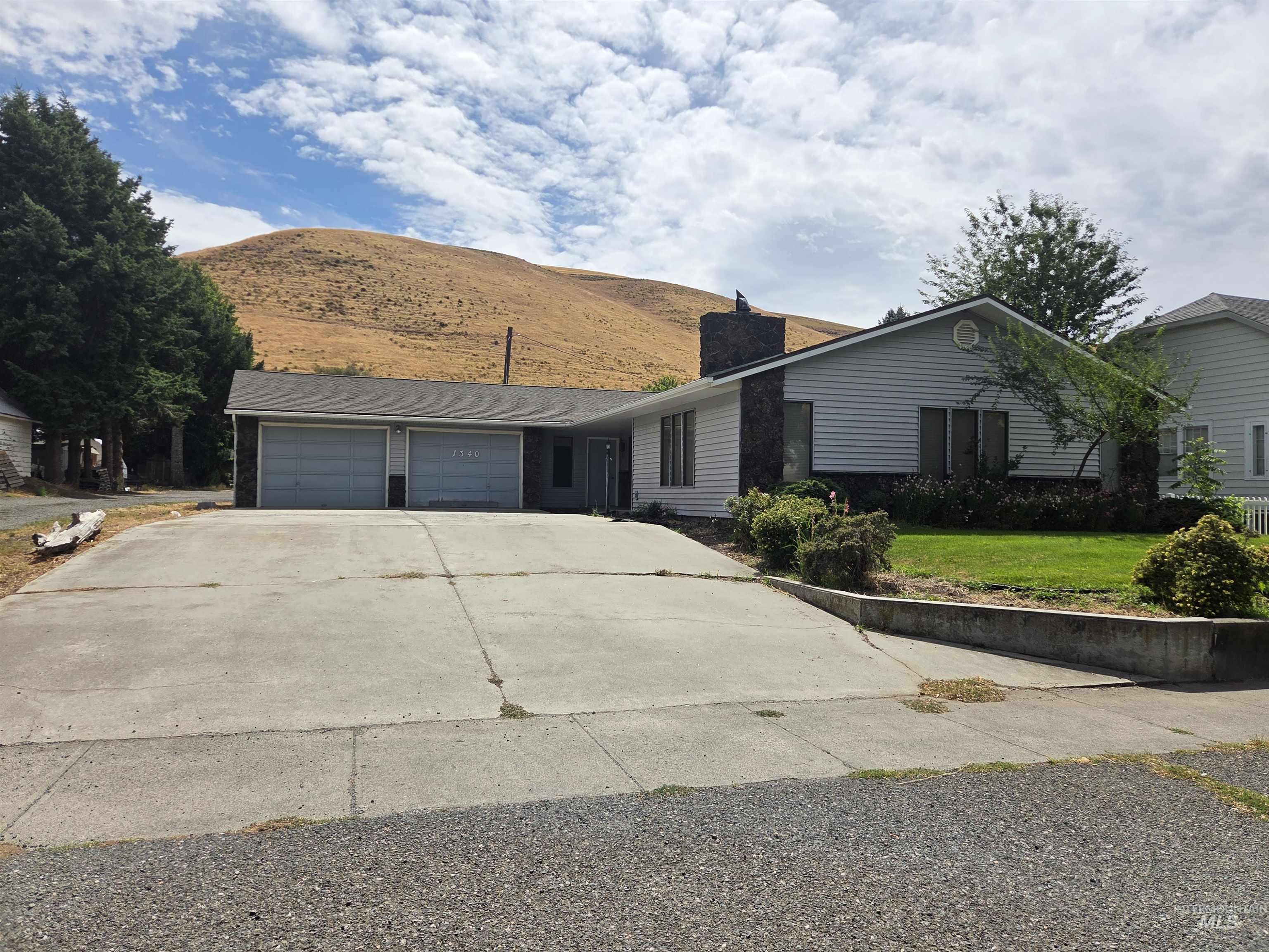 1340 Pataha Street Pomeroy, WA 99347 - Photo 1 of 1 Ranch-style home with a chimney, an attached garage, driveway, a front yard, and a mountain view