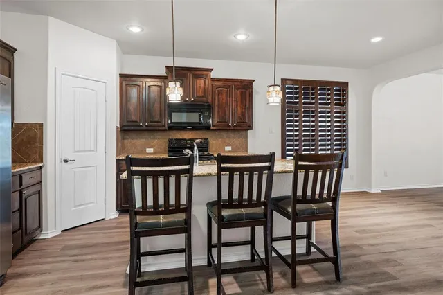 a kitchen with a table chairs refrigerator and microwave