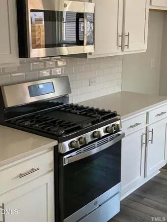 a stove top oven sitting inside of a kitchen