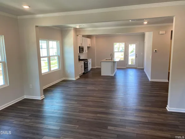 a view of a living room with hardwood floor and windows