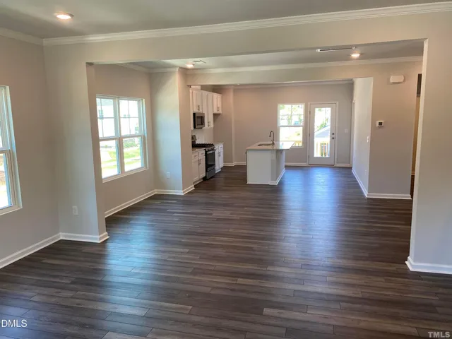 a view of a living room with hardwood floor and windows