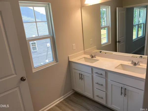 a bathroom with a double vanity sink and a window