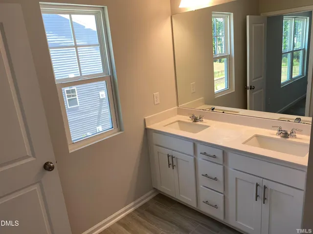 a bathroom with a double vanity sink and a window