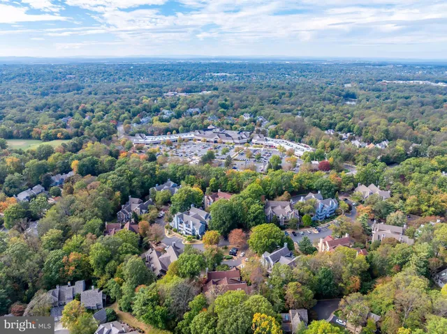 an aerial view of residential house with outdoor space and trees all around