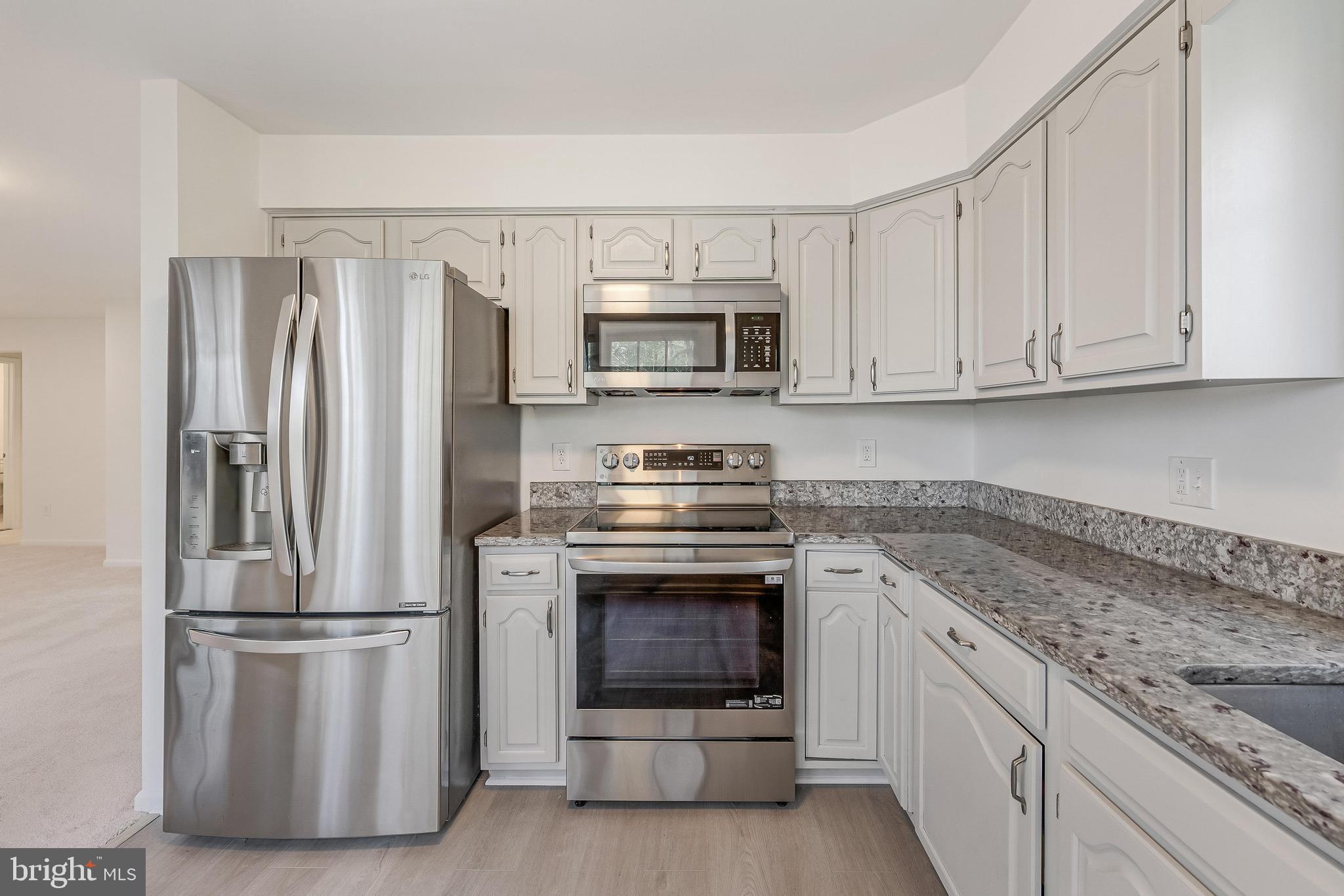 1483 Church Hill Place Reston, VA 20194 - Photo 4 of 38 a kitchen with granite countertop a refrigerator stove and microwave