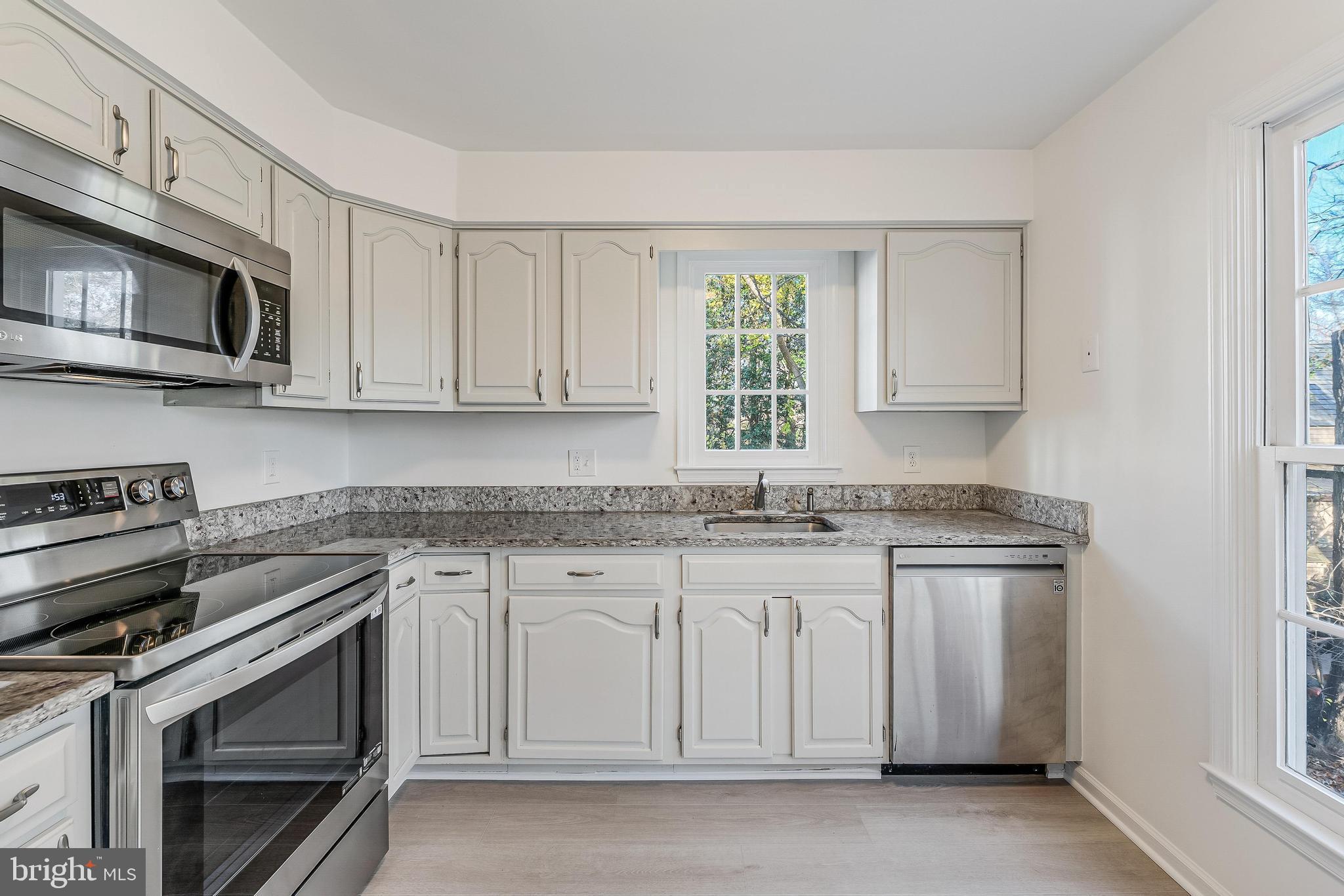1483 Church Hill Place Reston, VA 20194 - Photo 5 of 38 a kitchen with stainless steel appliances granite countertop white cabinets and a stove top oven