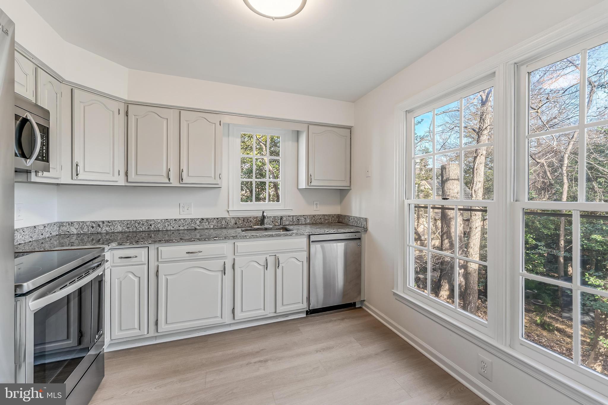 1483 Church Hill Place Reston, VA 20194 - Photo 6 of 38 a kitchen with stainless steel appliances granite countertop a stove a sink and a microwave