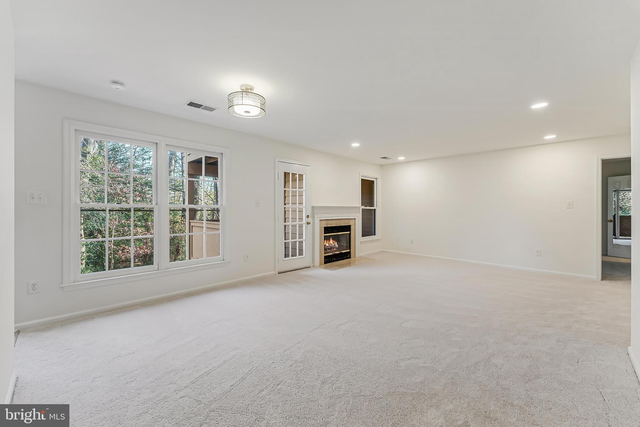 1483 Church Hill Place Reston, VA 20194 - Photo 7 of 38 an empty room with a fireplace and windows