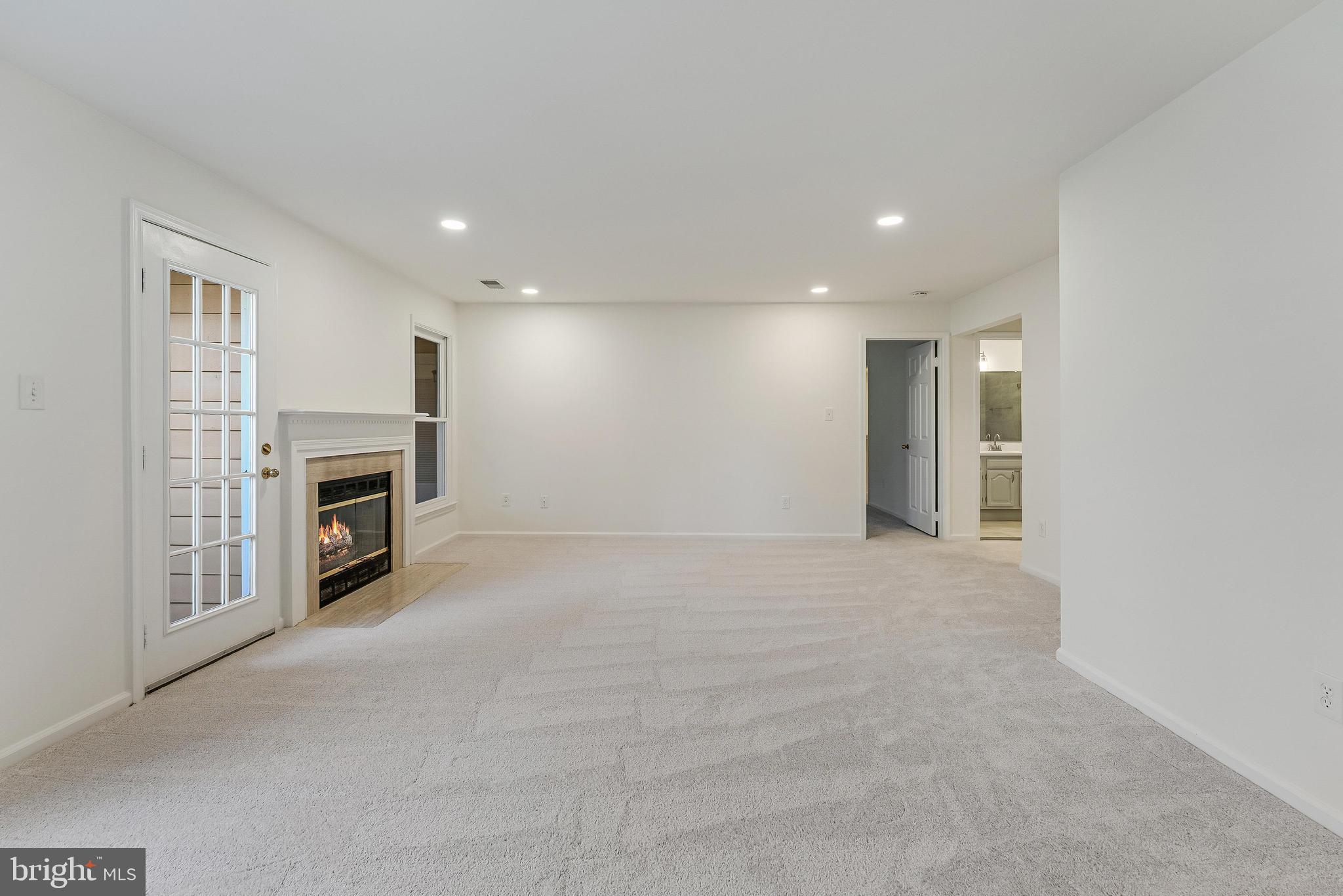 1483 Church Hill Place Reston, VA 20194 - Photo 8 of 38 a view of a livingroom with a fireplace a ceiling fan and windows