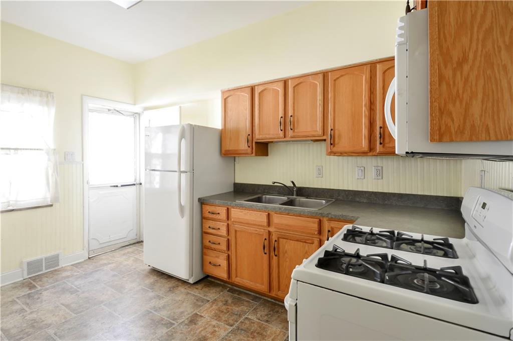 234 Hickory Street McKees Rocks, PA 15136 - Photo 3 of 12 a kitchen with a stove a refrigerator and a wooden cabinets