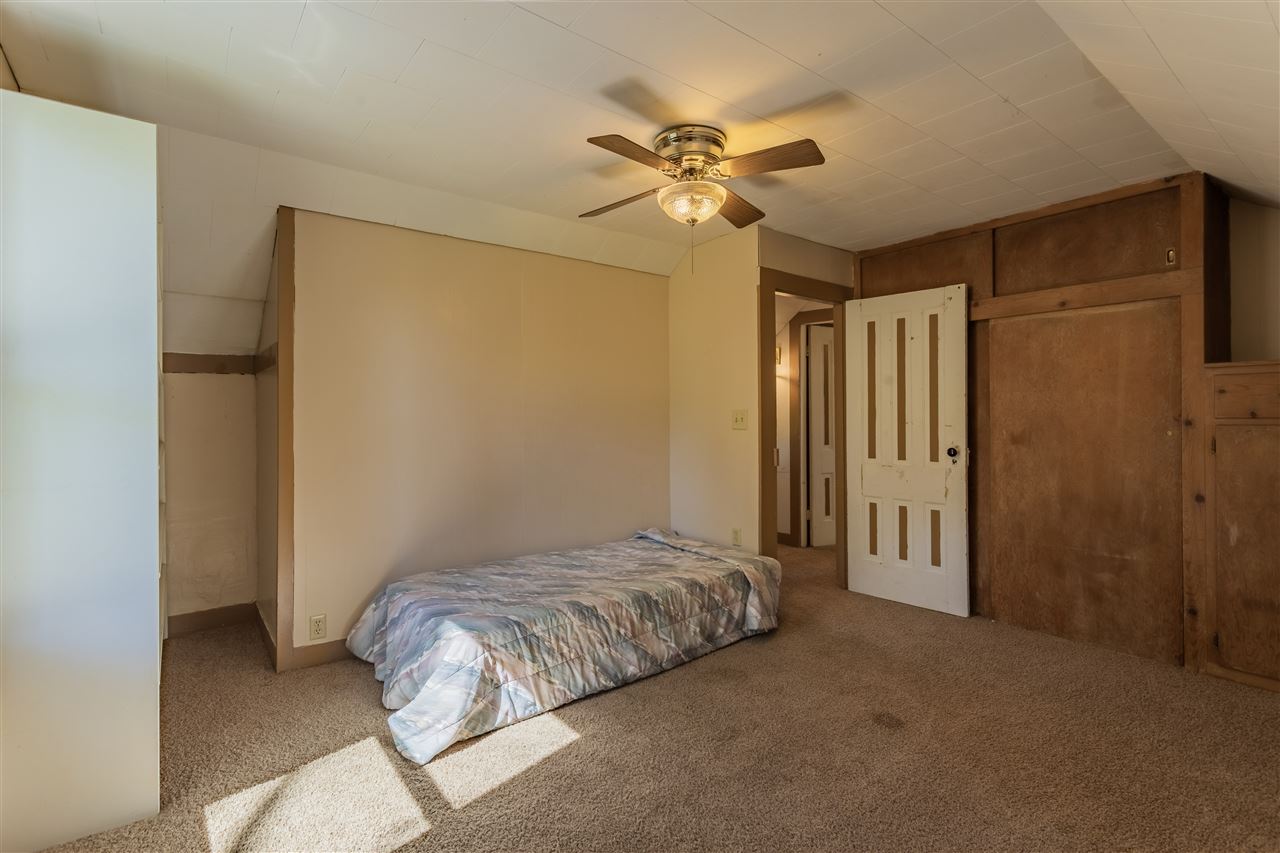 9639 East River Road Ridott, IL 61067 - Photo 19 of 32 a bedroom with a bed and a chandelier