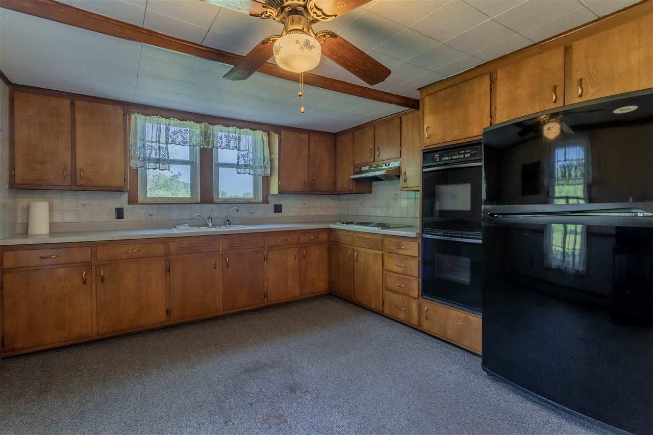 9639 East River Road Ridott, IL 61067 - Photo 8 of 32 a kitchen with stainless steel appliances kitchen island granite countertop a stove sink and cabinets
