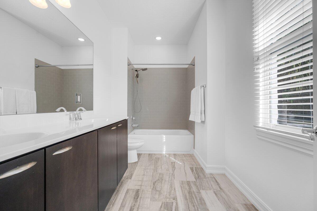 120 West Bay Cedar Circle Jupiter, FL 33458 - Photo 19 of 33 a bathroom with a sink a toilet a mirror and shower