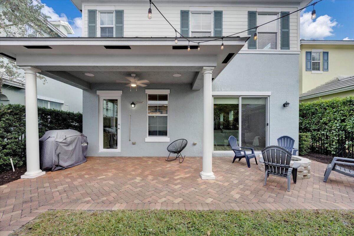 120 West Bay Cedar Circle Jupiter, FL 33458 - Photo 26 of 33 a view of a patio with table and chairs potted plants and large tree
