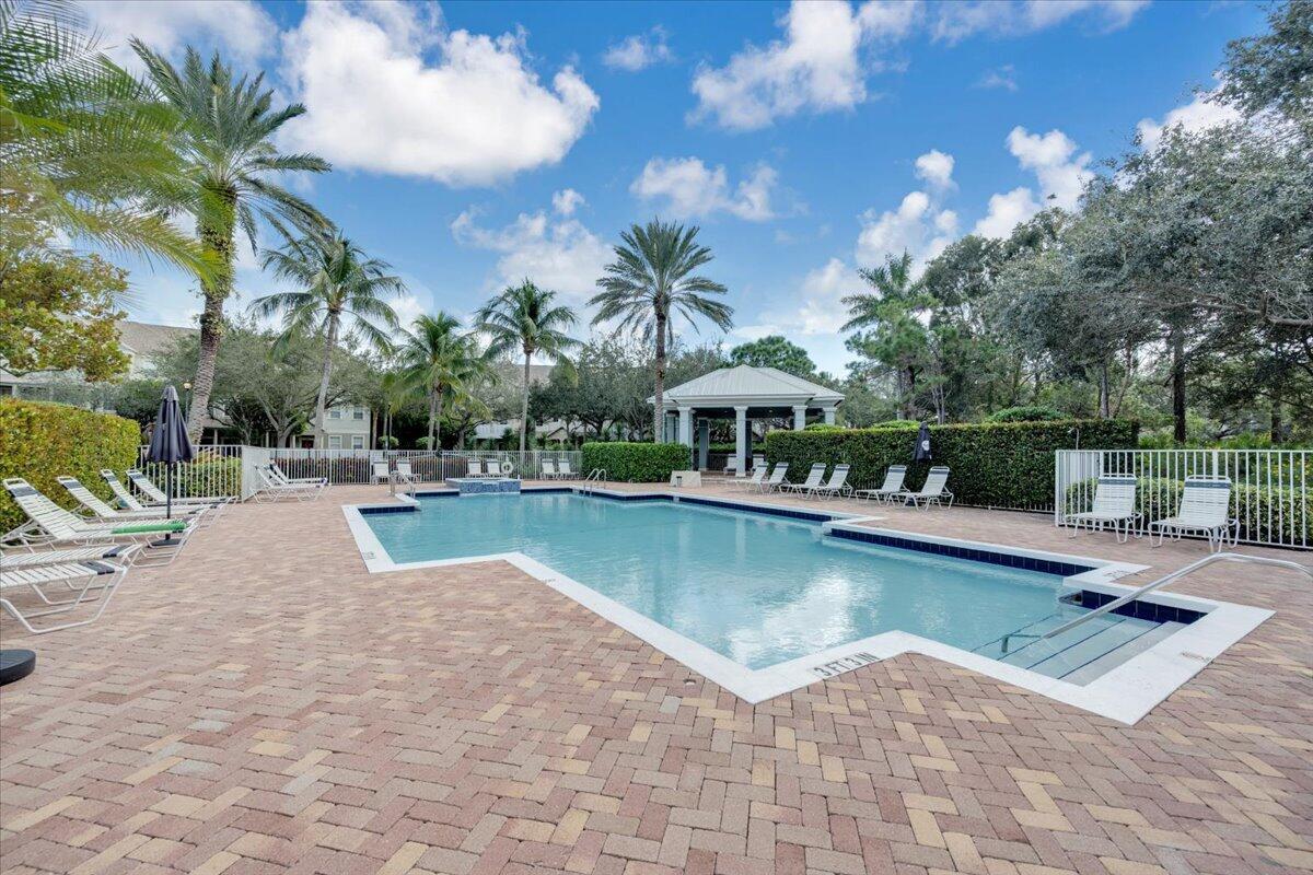 120 West Bay Cedar Circle Jupiter, FL 33458 - Photo 32 of 33 a view of a swimming pool with lounge chairs in patio