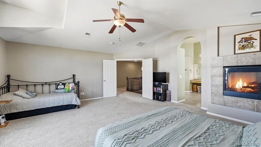 7869 Solstice Way Castle Rock, CO 80108 - Photo 19 of 41 a bedroom with a bed and a flat screen tv