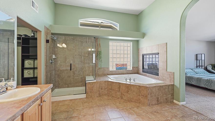 7869 Solstice Way Castle Rock, CO 80108 - Photo 20 of 41 a spacious bathroom with a granite countertop tub shower and sink