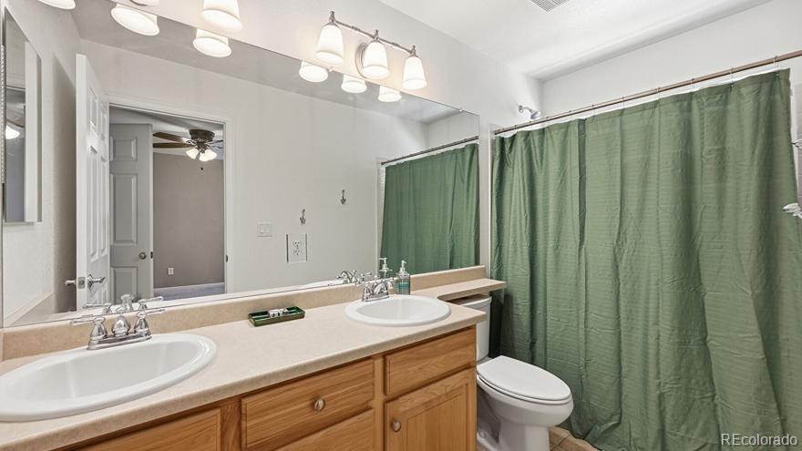 7869 Solstice Way Castle Rock, CO 80108 - Photo 24 of 41 a bathroom with a double vanity sink toilet and a mirror