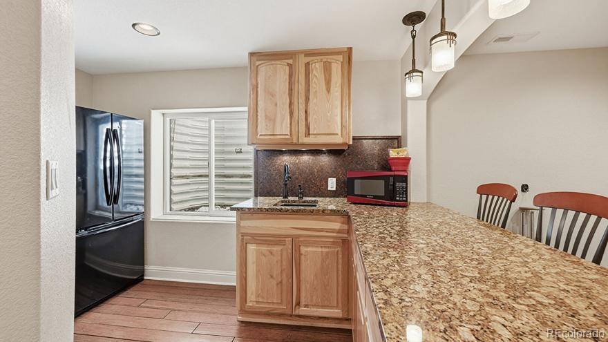 7869 Solstice Way Castle Rock, CO 80108 - Photo 34 of 41 a kitchen with granite countertop a refrigerator and a stove top oven