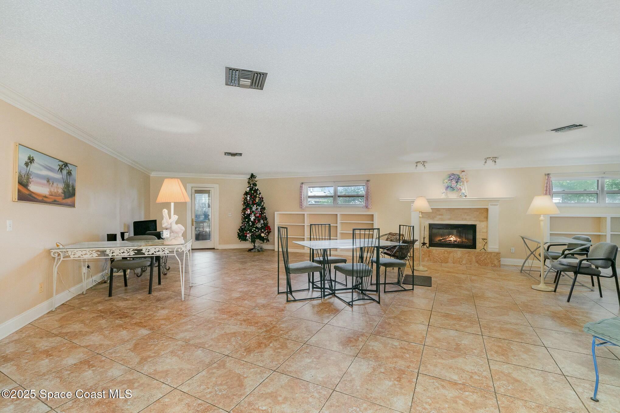 1351 Cherry Hills Road Northeast Palm Bay, FL 32905 - Photo 12 of 27 a living room with furniture a dining table and a fireplace