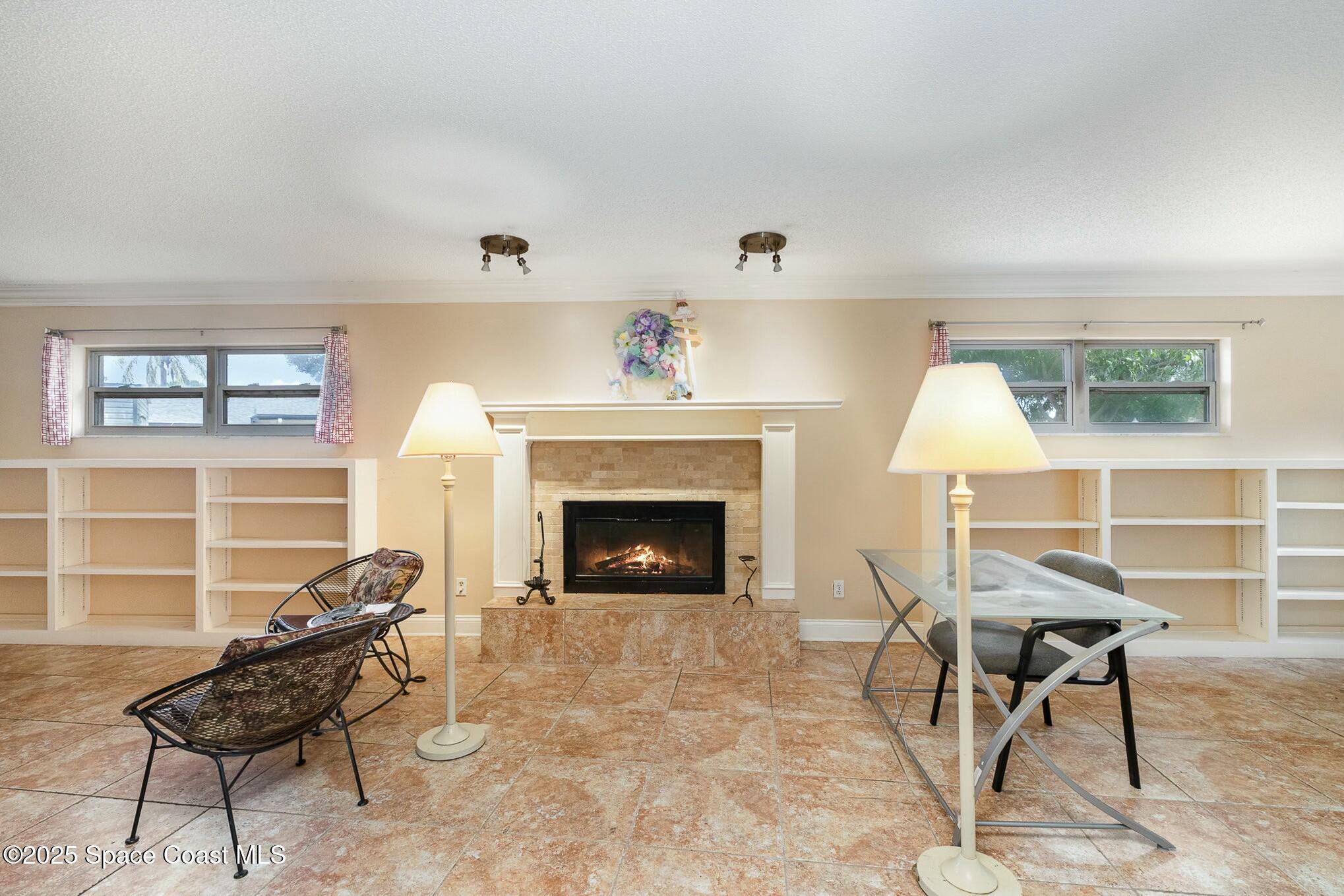 1351 Cherry Hills Road Northeast Palm Bay, FL 32905 - Photo 13 of 27 a living room with furniture a fireplace and a window