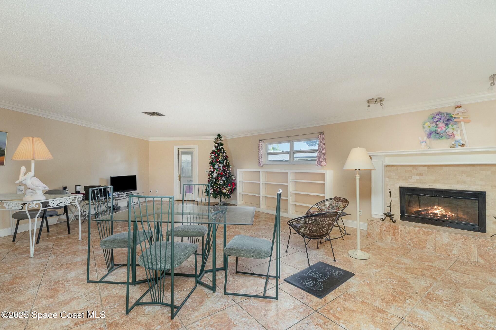1351 Cherry Hills Road Northeast Palm Bay, FL 32905 - Photo 14 of 27 a living room with furniture a fireplace and a table