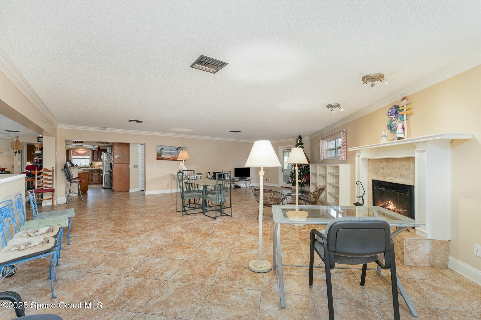1351 Cherry Hills Road Northeast Palm Bay, FL 32905 - Photo 15 of 27 a living room with furniture a fireplace and a table