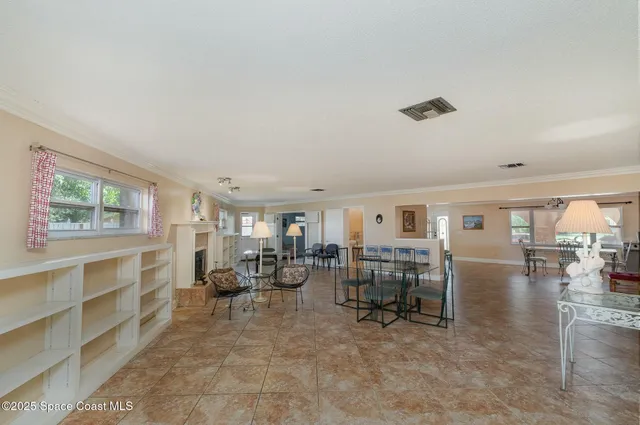 a living room with furniture and a dining table with kitchen view