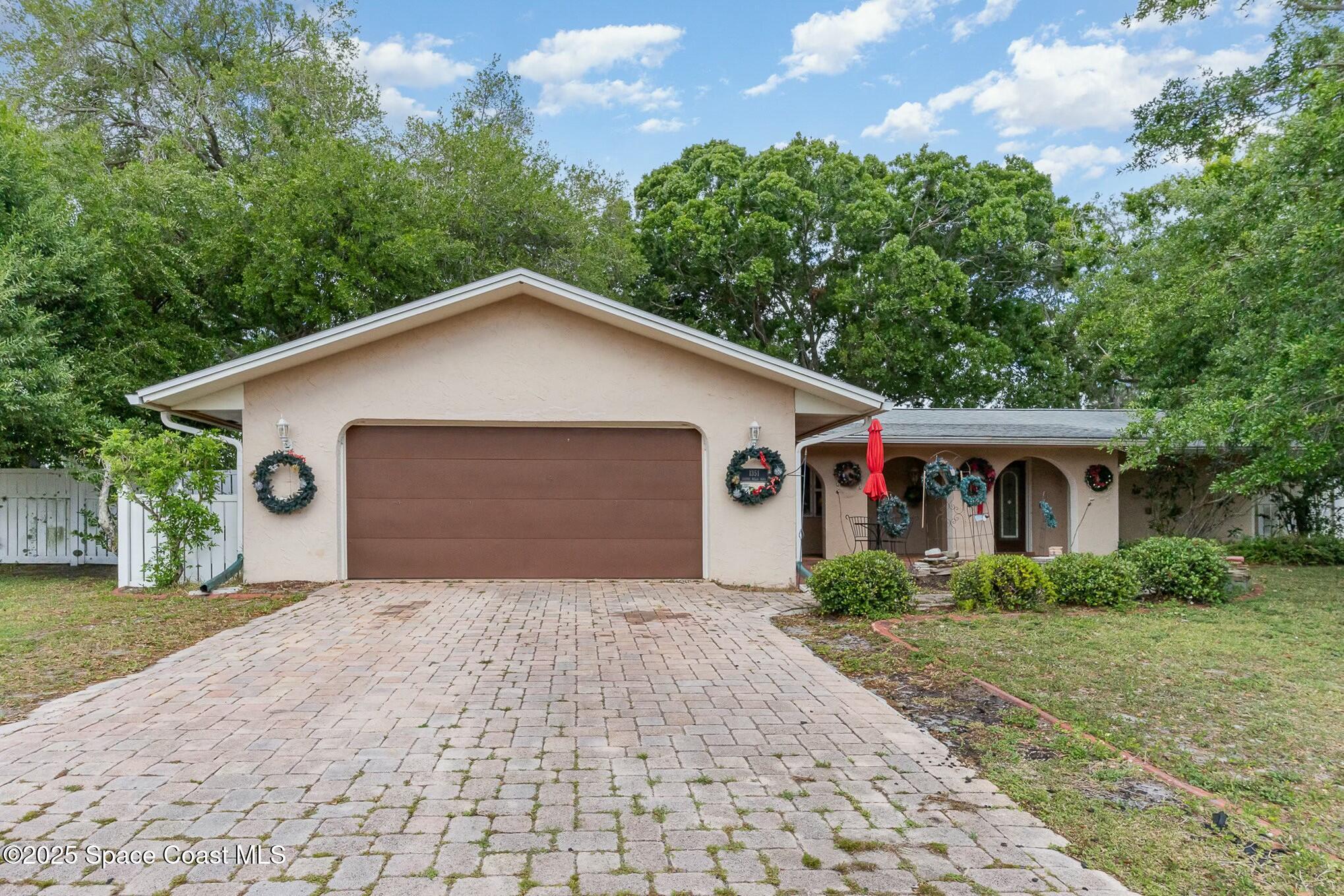 1351 Cherry Hills Road Northeast Palm Bay, FL 32905 - Photo 2 of 27 a front view of house with yard and trees around
