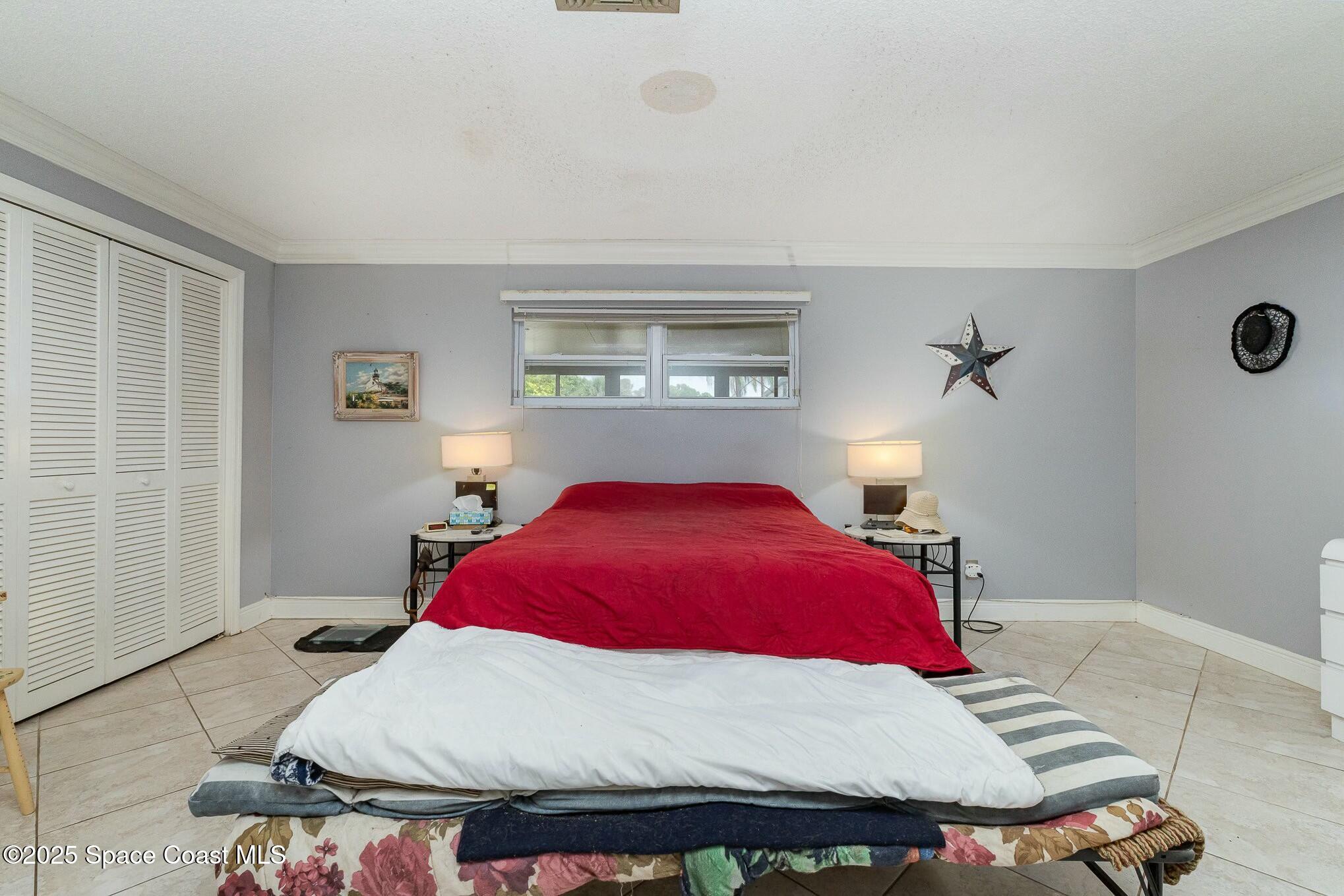 1351 Cherry Hills Road Northeast Palm Bay, FL 32905 - Photo 21 of 27 a bedroom with a bed and window