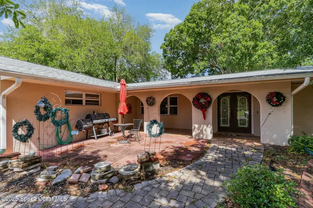 a view of a patio with table and chairs and potted plants