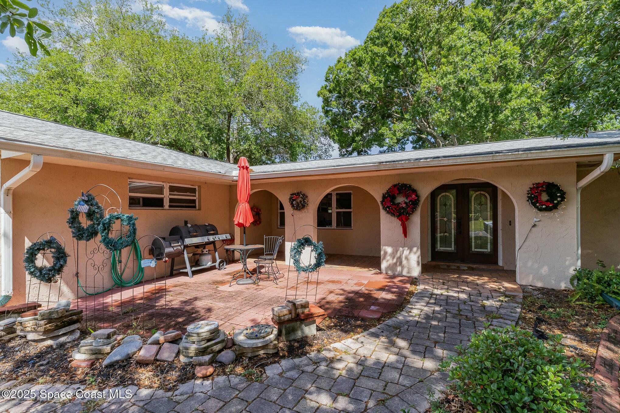 1351 Cherry Hills Road Northeast Palm Bay, FL 32905 - Photo 3 of 27 a view of a patio with table and chairs and potted plants