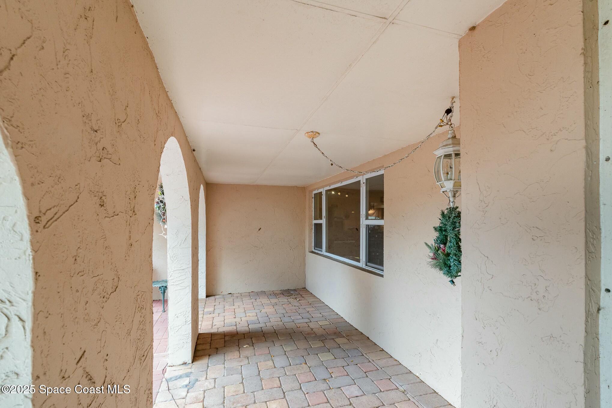 1351 Cherry Hills Road Northeast Palm Bay, FL 32905 - Photo 4 of 27 a view of a hallway with wooden floor and a bathroom