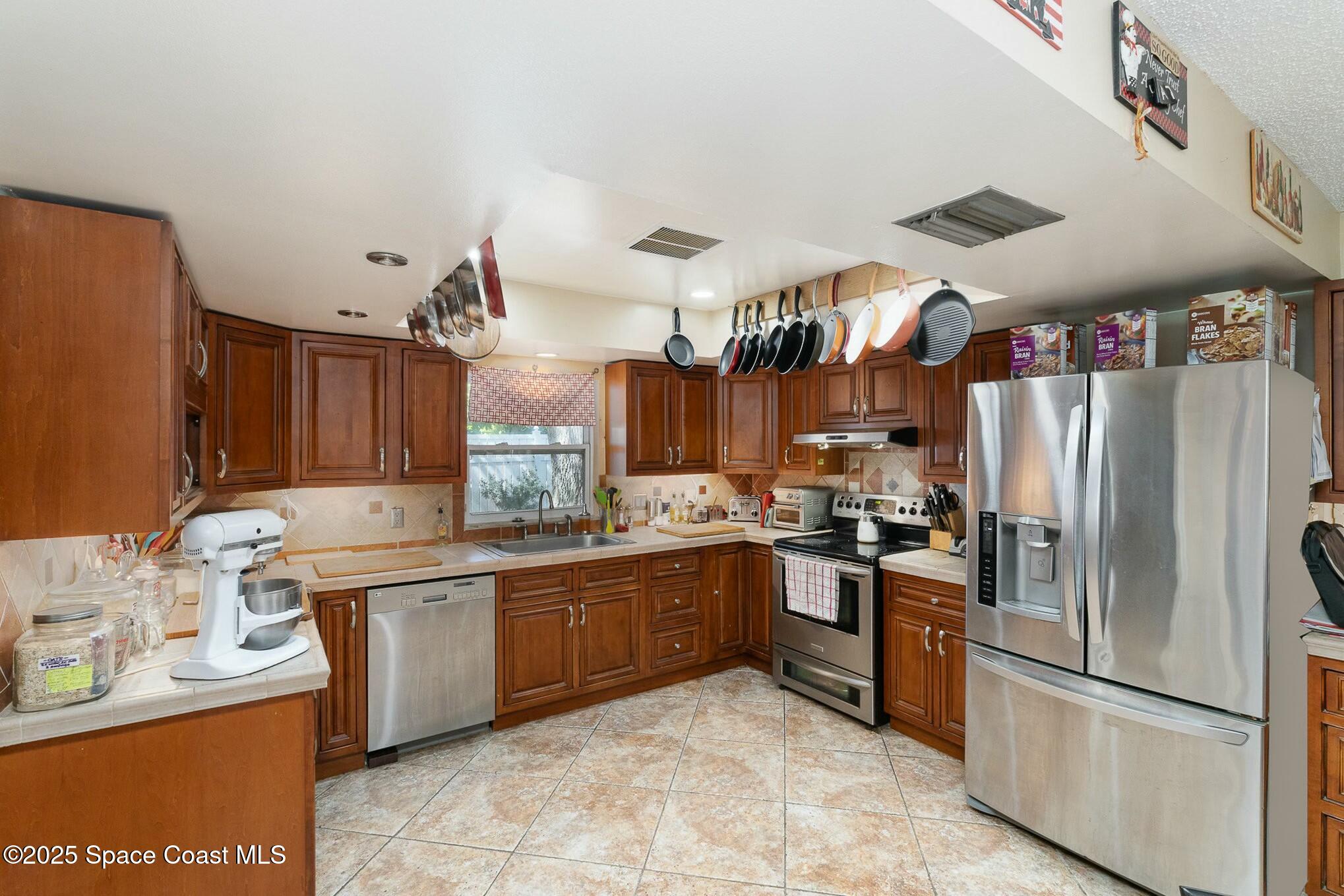 1351 Cherry Hills Road Northeast Palm Bay, FL 32905 - Photo 8 of 27 a kitchen with granite countertop a sink stainless steel appliances and cabinets