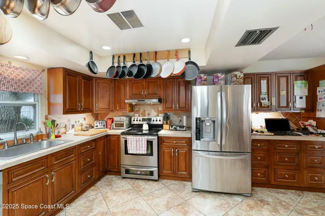 a kitchen with stainless steel appliances granite countertop a refrigerator and a sink