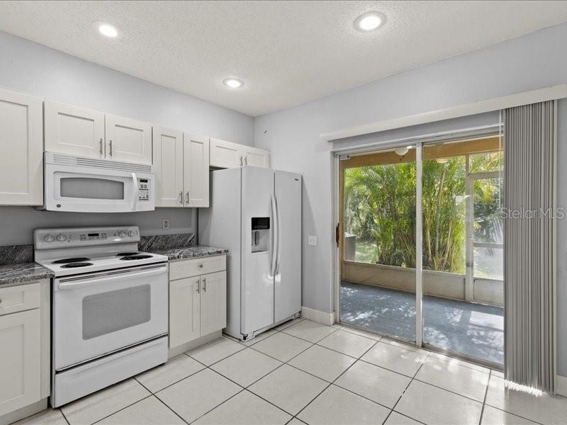 29924 Playa Del Rey Lane Wesley Chapel, FL 33543 - Photo 7 of 31 a kitchen with white cabinets and white appliances