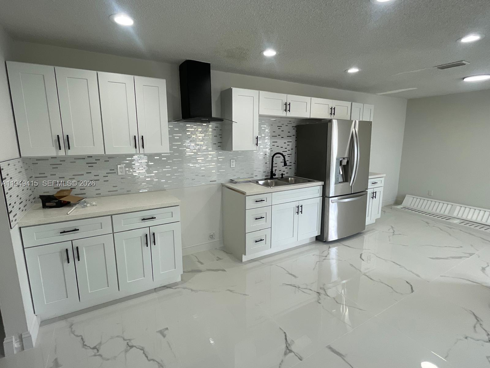 a kitchen with white cabinets stainless steel appliances and sink