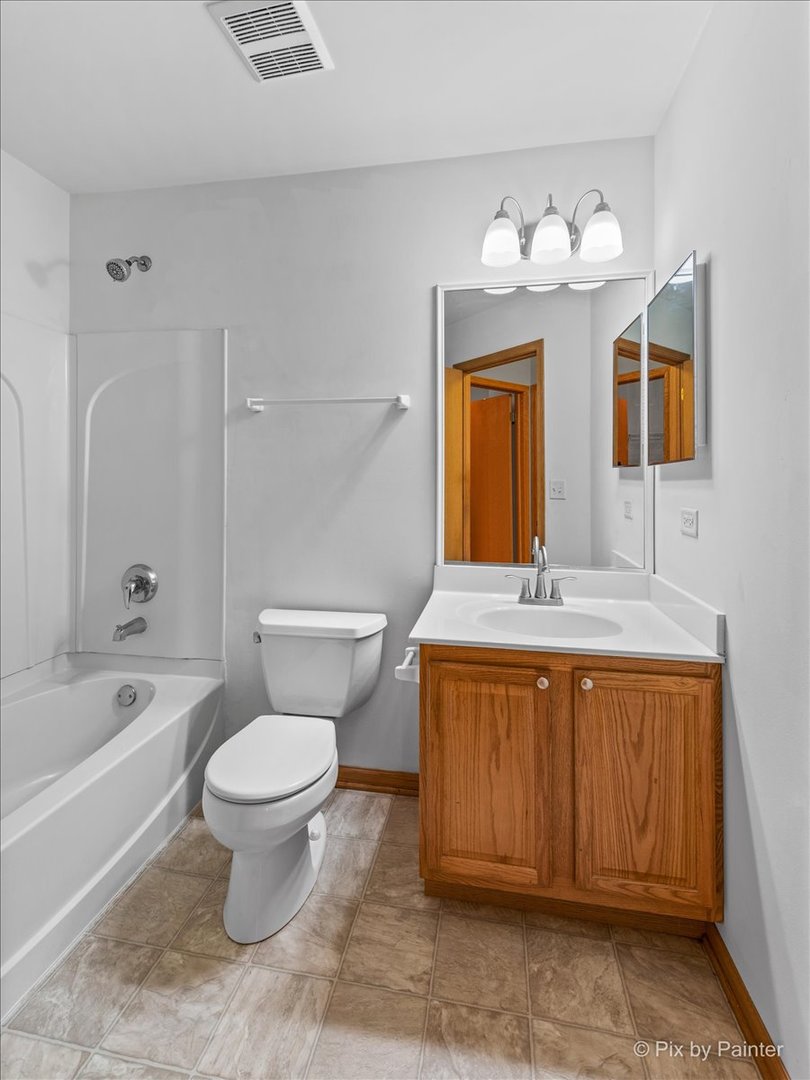 9433 Rainsford Drive, Unit 9433 Huntley, IL 60142 - Photo 25 of 30 a bathroom with a toilet sink and mirror