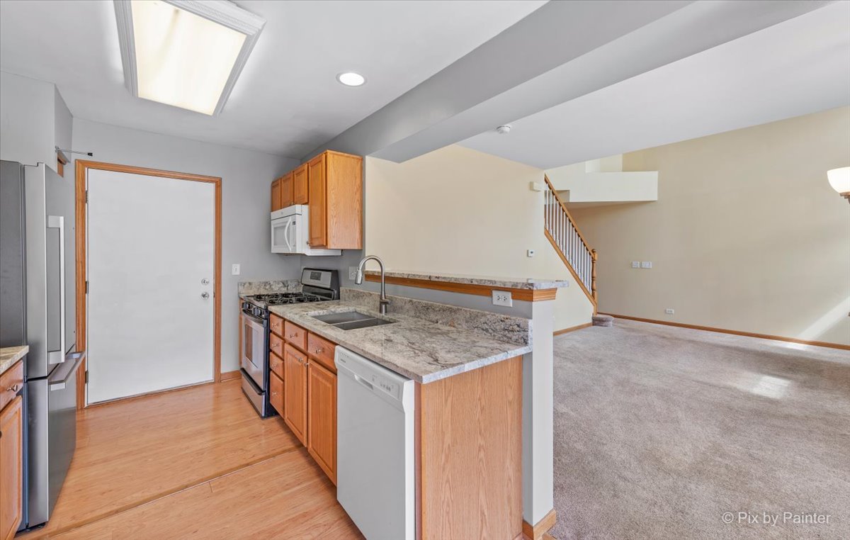 9433 Rainsford Drive, Unit 9433 Huntley, IL 60142 - Photo 10 of 30 a kitchen with a stove and a sink