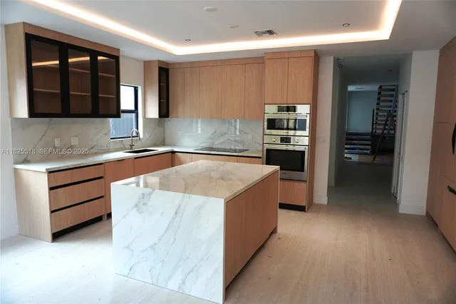 a kitchen that has a sink and a stove in it