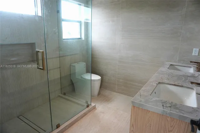a bathroom with a granite countertop sink a toilet and shower