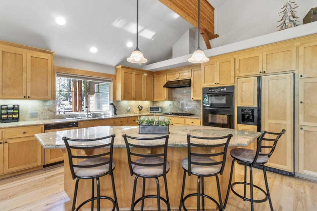 11347 Ski Slope Way Truckee, CA 96161 - Photo 9 of 21 a kitchen with stainless steel appliances kitchen island granite countertop a table chairs and a refrigerator