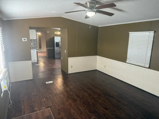 a view of a livingroom with wooden floor and a ceiling fan