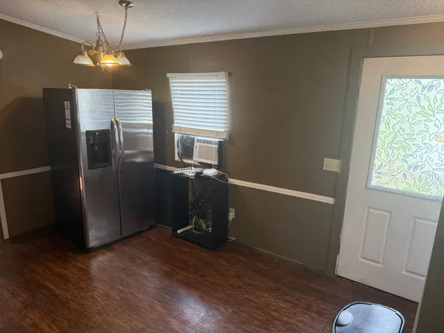 a kitchen with granite countertop a refrigerator a stove a sink a window and cabinets