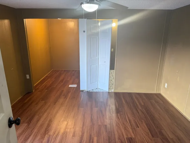 a view of a room with wooden floor and a window