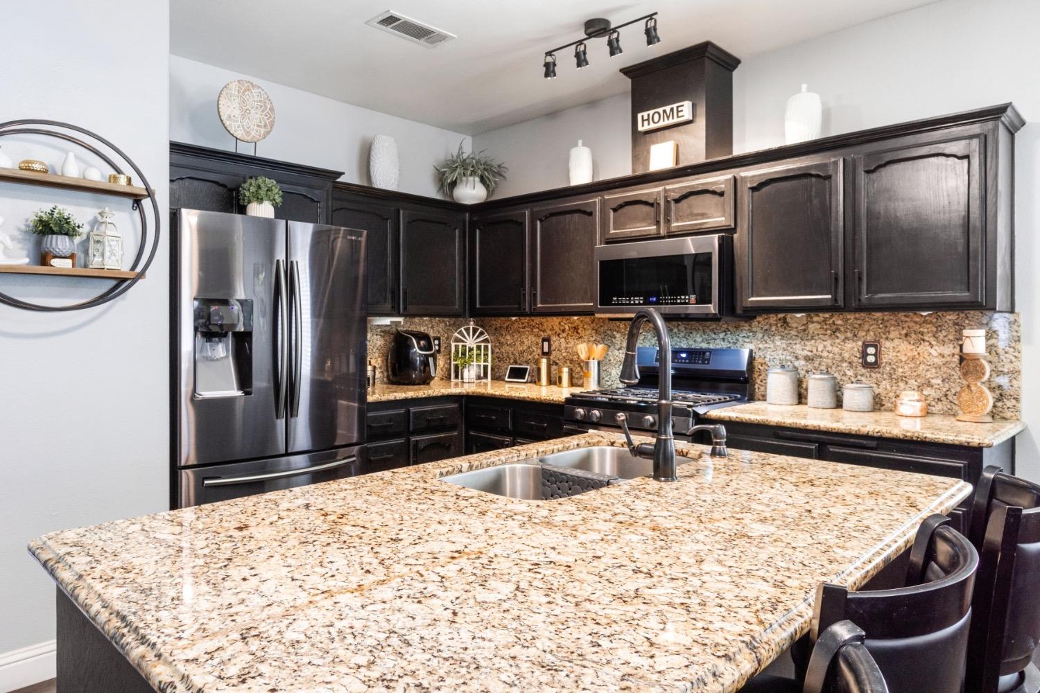 2658 Kimberly Drive Madera, CA 93637 - Photo 8 of 27 a kitchen with stainless steel appliances granite countertop a sink refrigerator and microwave