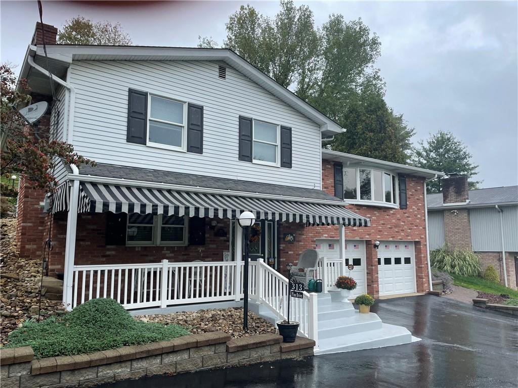 313 Pine Drive New Stanton, PA 15672 - Photo 1 of 41 a front view of a house with a garden