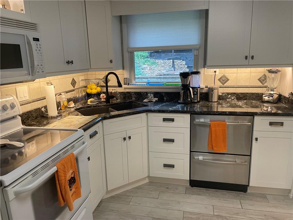313 Pine Drive New Stanton, PA 15672 - Photo 12 of 41 a kitchen with granite countertop white cabinets and white appliances