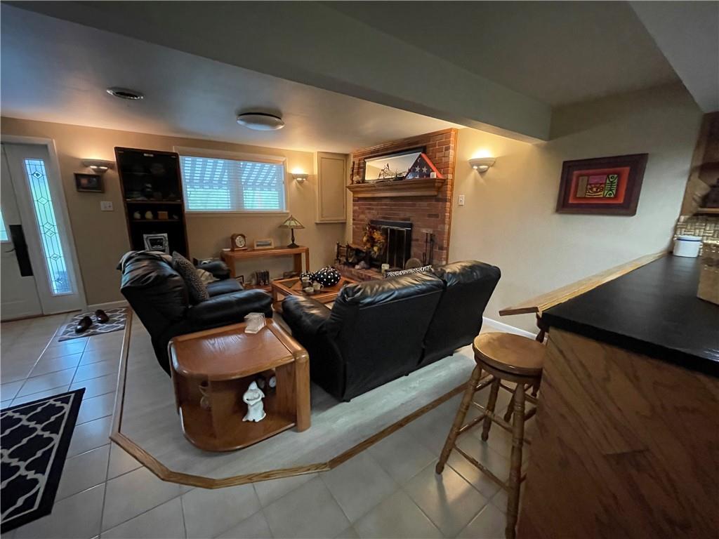313 Pine Drive New Stanton, PA 15672 - Photo 34 of 41 a living room with furniture a fireplace and a flat screen tv